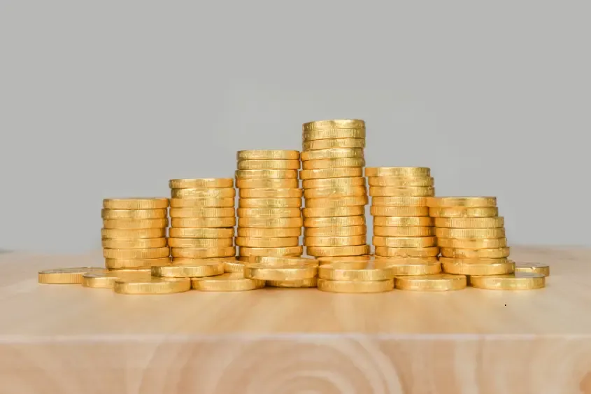 Pilhas de moedas sobre uma mesa de madeira
