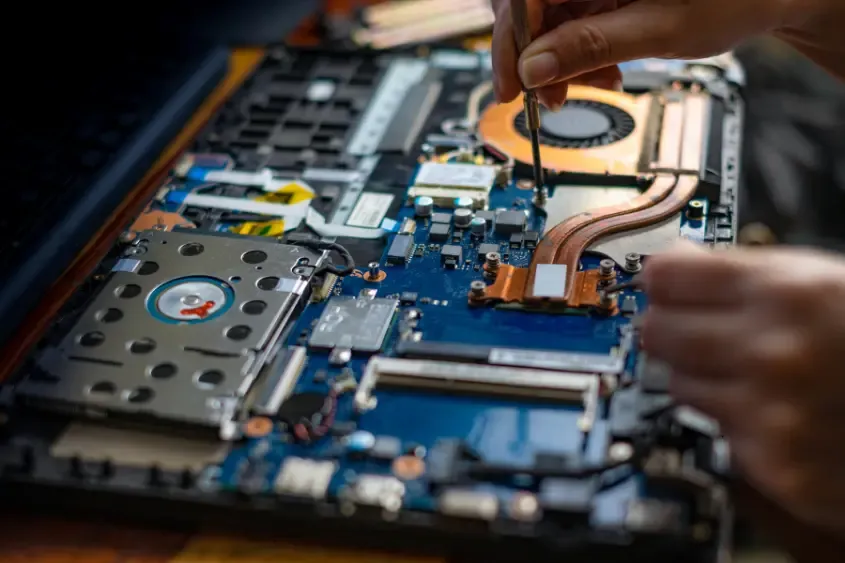 Técnico trabalhando na placa de um notebook aberto